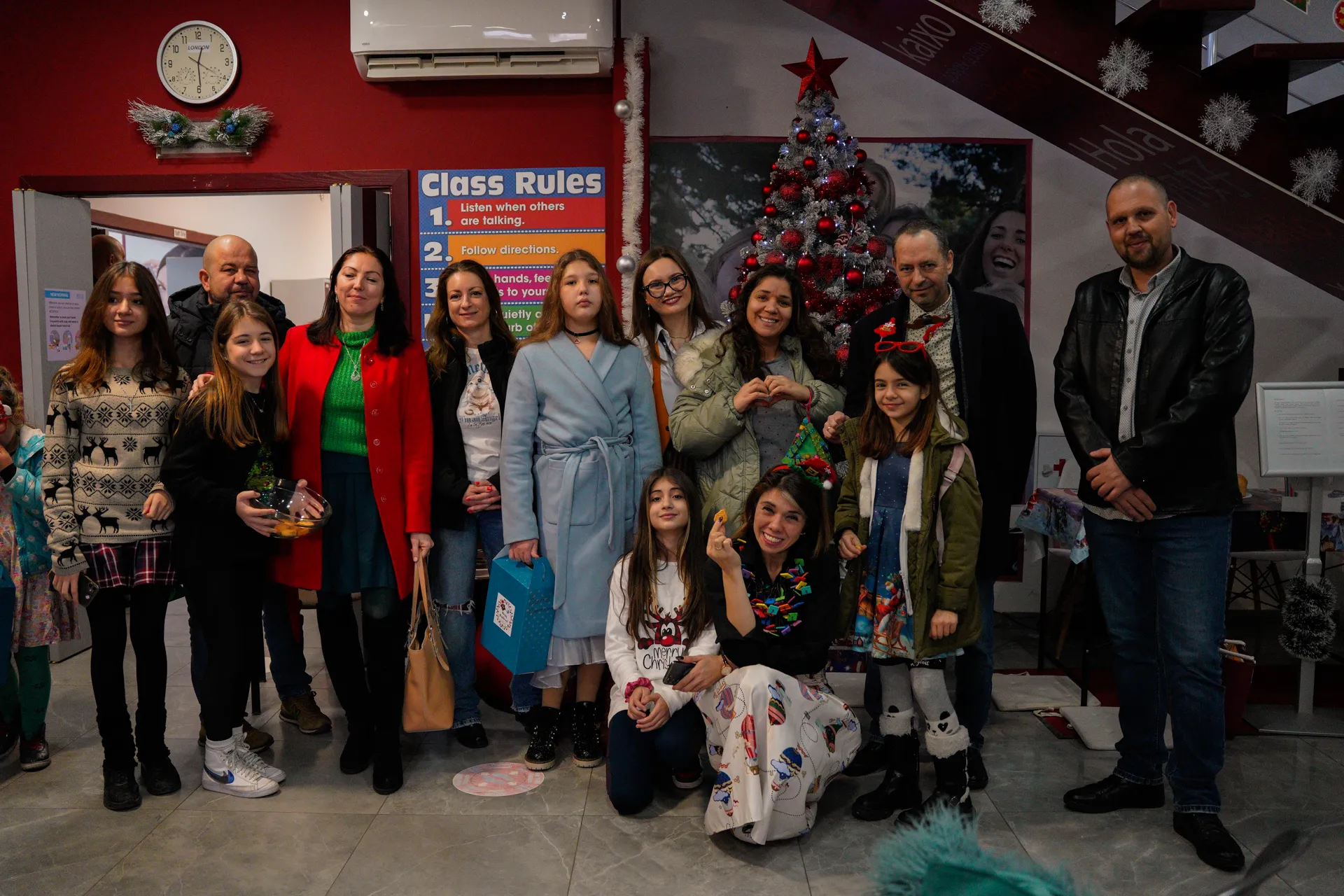 Families and children by the Christmas tree in the school lobby