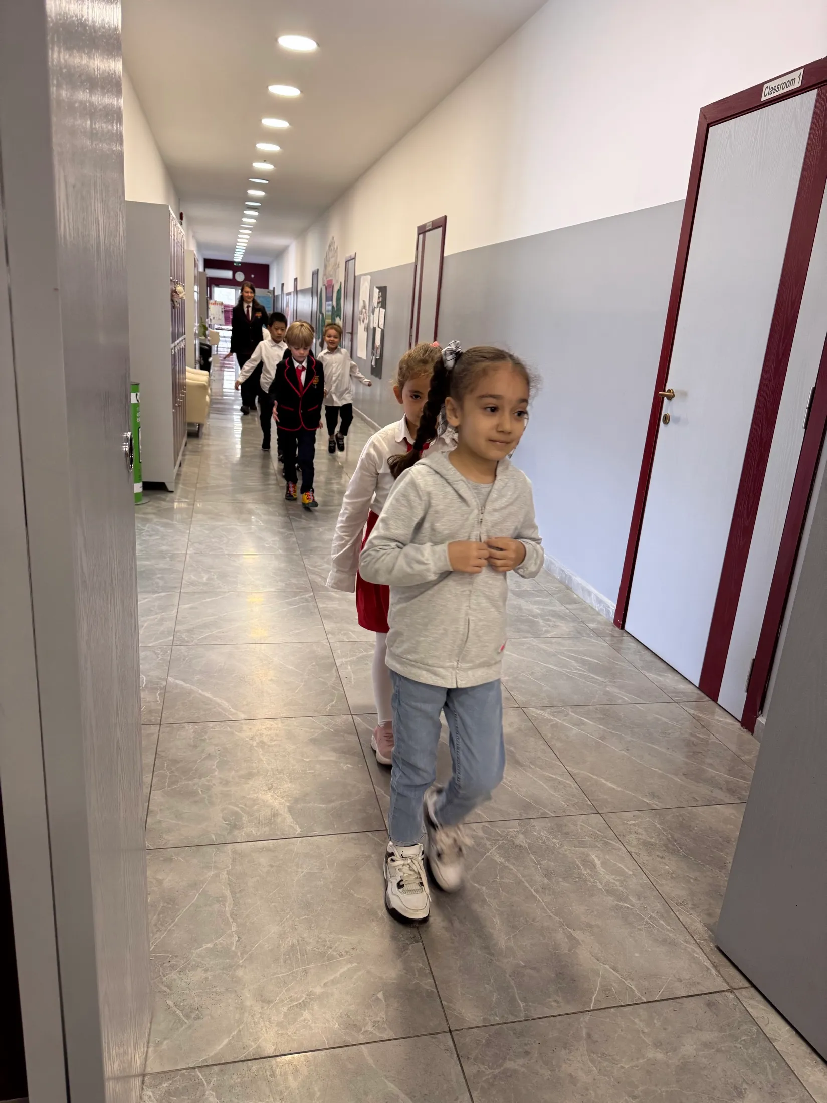 First graders walking down the school hallway together in a line