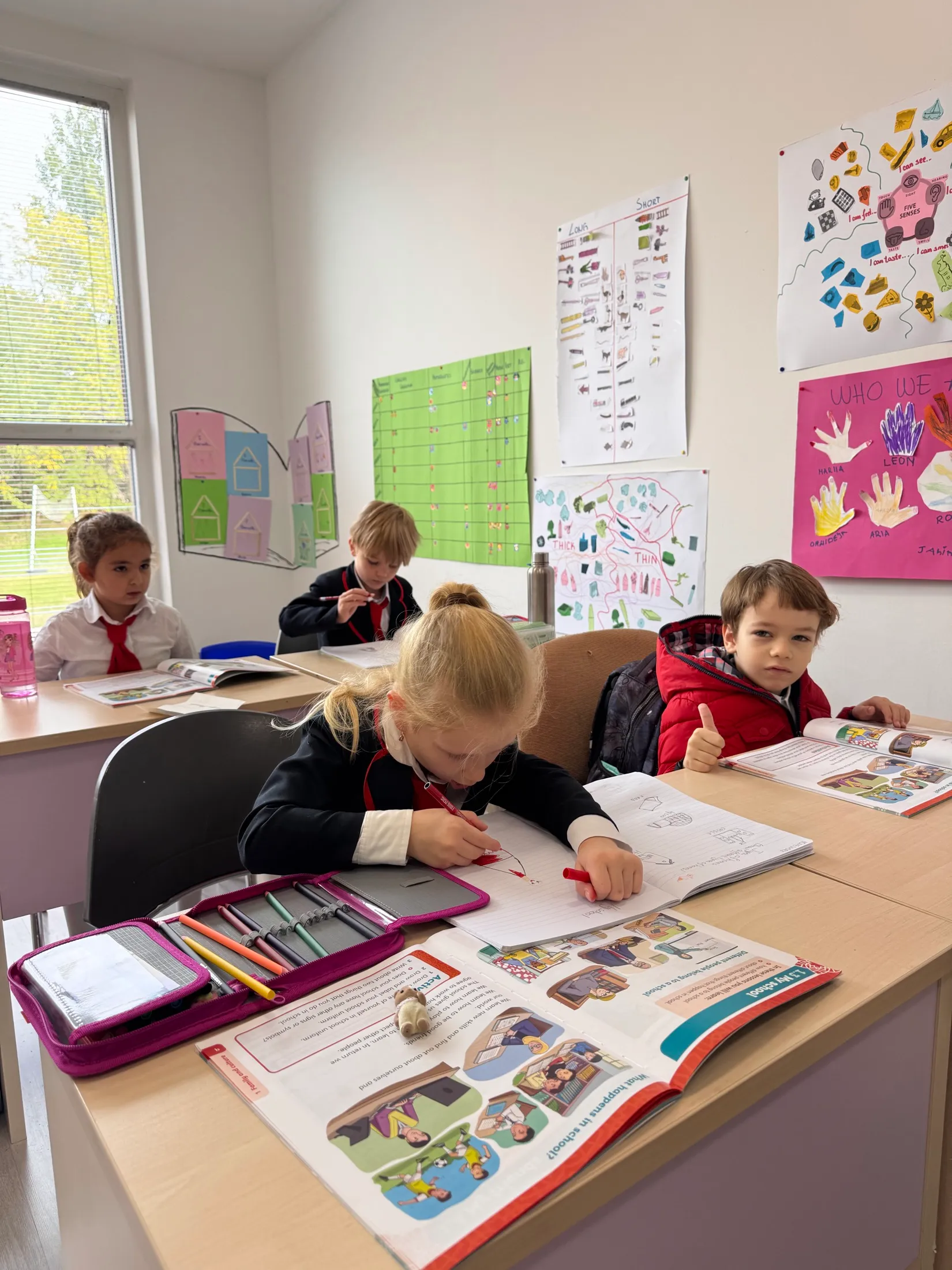 Workbooks open across the desks mid-lesson
