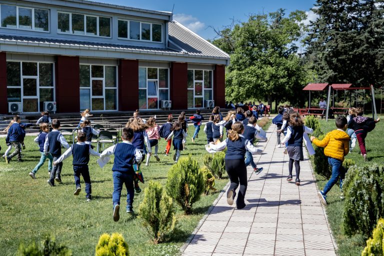 Energetic students at International School Maximilian in Skopje enjoy a sunny day outdoors on the school's verdant grounds, exemplifying the school's dynamic learning environment and commitment to holistic education.